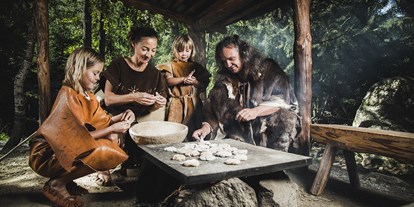 Ausflug mit Kindern - Tiroler Oberland - Steinzeitfamilie beim Brotbacken im Ötzi-Dorf - Ötzi-Dorf und Greifvogelpark