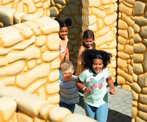 Kinder laufen durch das begehbare verrückte Labyrinth im Ravensburger Spieleland